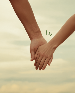 Las manos de dos enamorados tocándose frente a un paisaje de nubes. Las manos se tocan palma con palma, pero la mano del hombre no agarra la de la mujer, demostrando la ambivalencia de un hombre evitativo enamorado.