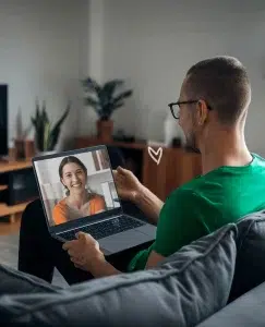 Un hombre manteniendo hablando con su pareja mediante el ordenador, mantiene una relación a distancia por Whatsapp