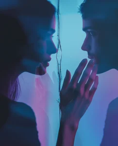en la imagen aparece una persona mirando al espejo a otra persona que no se pueden relacionar por un trauma relacional