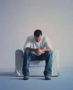 aparece un hombre sentado en un sillón haciendo referencia a las etapas del duelo amoroso en los hombres