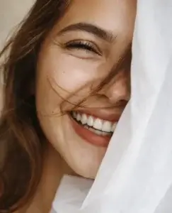 Primer plano de una mujer sonriendo con expresión cálida y cercana, una imagen que simboliza el amor y amistad, la complicidad emocional y el vínculo afectivo basado en la confianza y la alegría compartida.