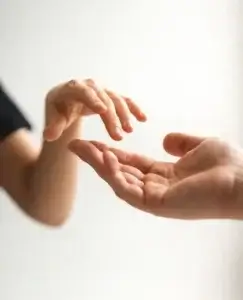 Manos acercándose con cuidado en un gesto de reconciliación y apoyo emocional, una imagen que simboliza el proceso de cómo perdonar una infidelidad y reconstruir la confianza tras una traición.