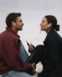 Pareja sentada frente a frente compartiendo auriculares, una imagen que refleja la búsqueda de conexión emocional y las relaciones intensas y ambiguas que pueden darse en el trastorno borderline.
