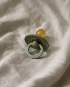 Un chupete descansa sobre una tela suave y arrugada, una imagen sencilla pero cargada de significado que evoca el delicado tema de mi pareja no quiere tener hijos, cuando los sueños de futuro dentro de la relación no siempre avanzan en la misma dirección.