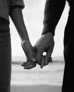 Dos personas entrelazando las manos, una imagen en blanco y negro que simboliza las segundas oportunidades en el amor.