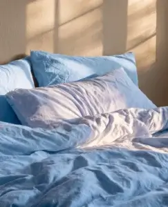Cama deshecha iluminada por la luz de la mañana, imagen asociada a la pregunta de qué significa soñar con tu ex.